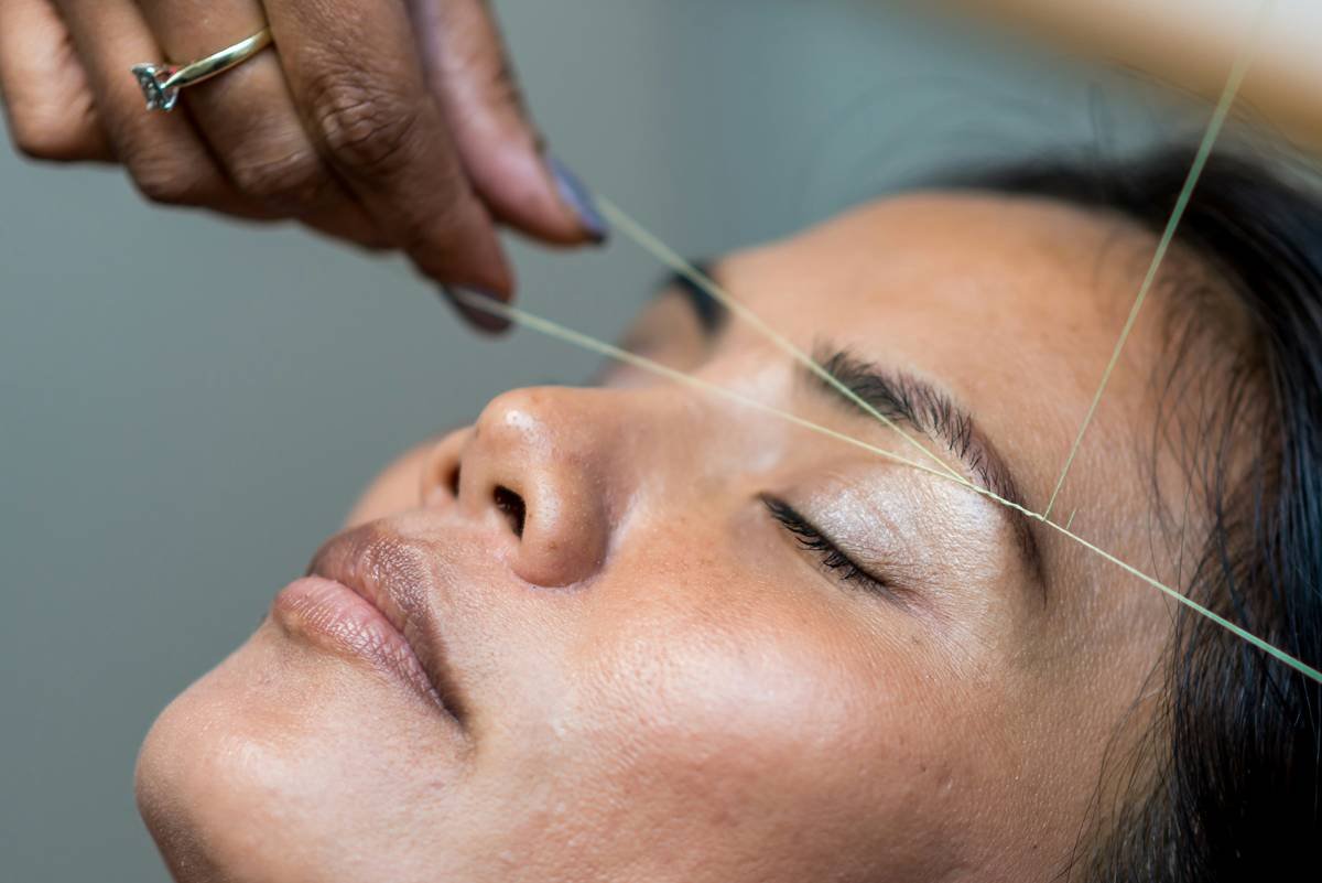 Woman applying brow lifting product with precision at hair roots for maximum lift effect